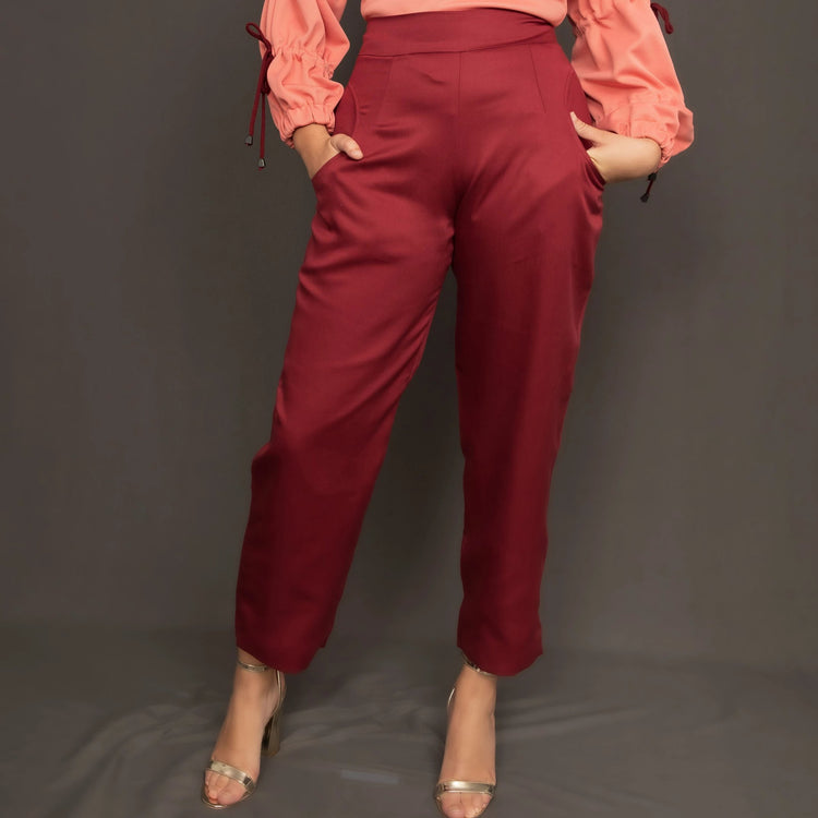 Model wearing high waist burgundy trousers by Kim Dave